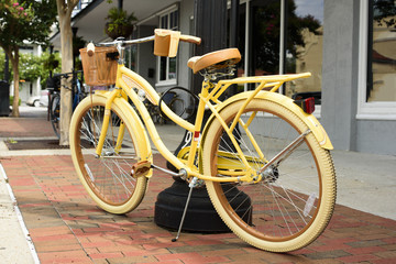 Fototapeta na wymiar Yellow bicycle on downtown sidewalk on Saturday morning