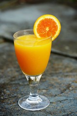 A glass of fresh orange juice with an orange slice