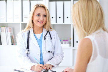 Doctor and  patient  discussing something while sitting at the table . Medicine and health care concept