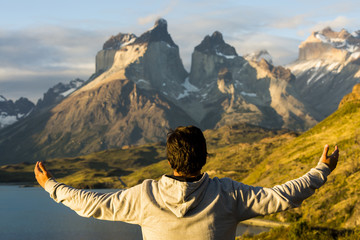 man with open arms over wonderful mountains landscape in Torres del Paine, Patagonia, Chile