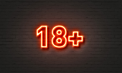 18+ neon sign on brick wall background.