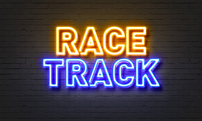 Race track neon sign on brick wall background.