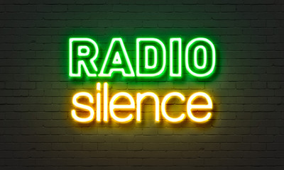 Radio silence neon sign on brick wall background.