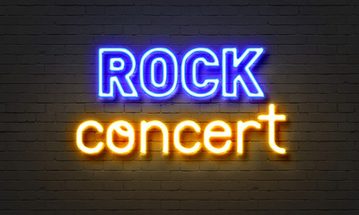 Rock concert neon sign on brick wall background.