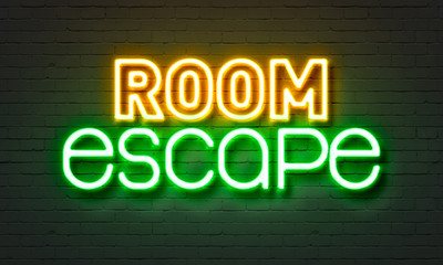 Room escape neon sign on brick wall background.