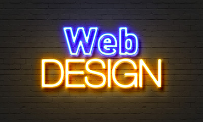 Web design neon sign on brick wall background.