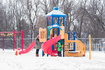 Mother and child at playground in snow