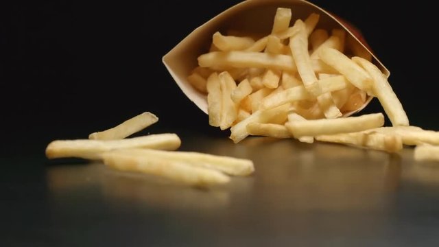 SLOW MOTION: Box with french fries falls on a table