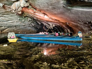 Obraz premium Long tail boats inside konglor cave in Laos