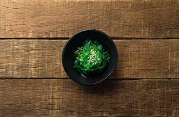 seasoned sesame seaweed japanese salad in black bowl and wood © TKBstudio