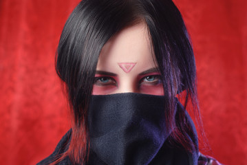 the girl with the covered face on a red background,