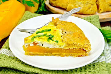 Pie of pumpkin and cheese in white plate on board