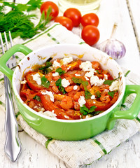 Shrimp and tomato with feta in pan on light board