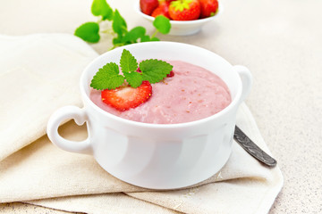 Soup strawberry in white bowl on granite table