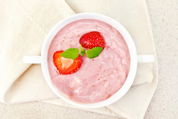 Soup strawberry in white bowl on granite table top