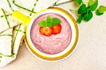Soup strawberry in yellow bowl on granite table top