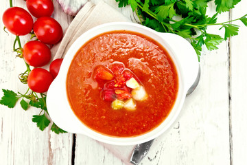 Soup tomato in white bowl with vegetables on board top