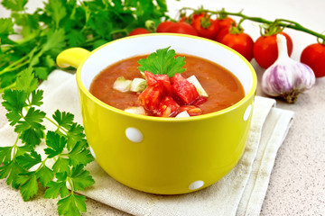 Soup tomato in yellow bowl on towel