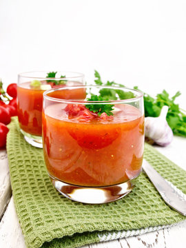 Soup tomato in two glasses with parsley on light board