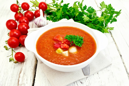 Soup tomato in white bowl with vegetables on napkin