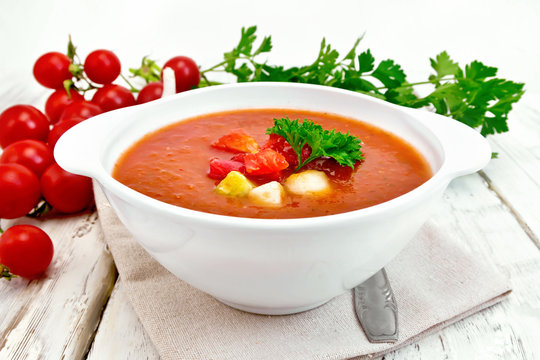 Soup tomato in white bowl with vegetables on towel