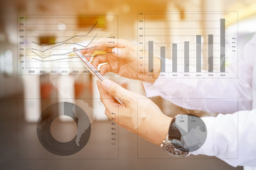 Asia business man hand touch screen on smartphone and business graph background.