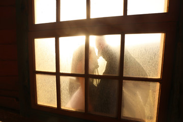 Groom and bride's reflection trough a window