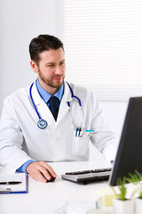 Male doctor working at computer