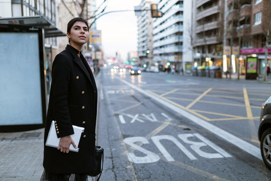 Woman with tablet at bus stop