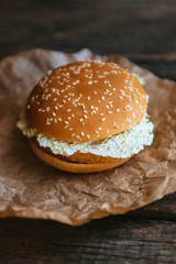 hamburger with chicken and lettuce on a wooden surface