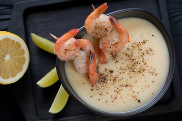 Close-up of a ceramic bowl with potato and shrimps cream-soup