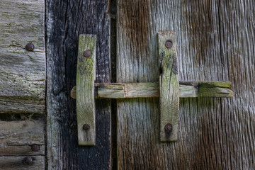 The wooden latch on a wooden door