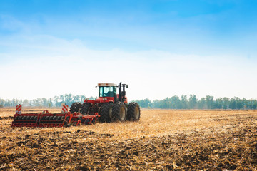 Fototapeta premium Modern tractor in the field with complex for the plowing of soil.