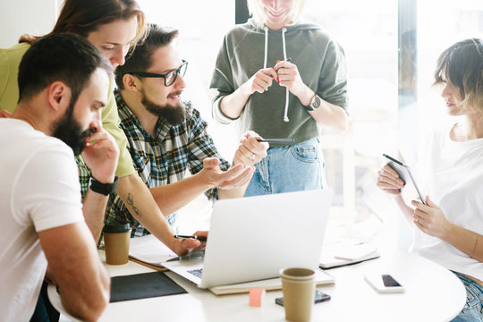 SMM specialists are discussing new creative concept for the new product marketing promotion. Group of freelancers are working on the new design project in the modern coworking space.
