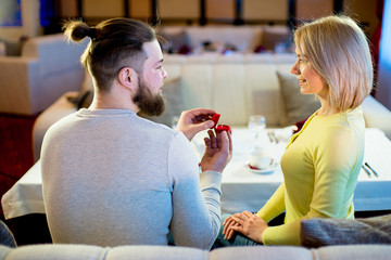 young man gives engagement ring