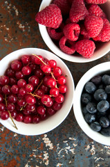 Berries in bowls on a rusty background