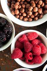 Berries, chocolate balls in bowls on a rusty background