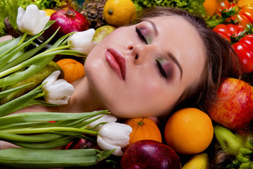 Woman in flowers and fruits with eyes closed, spring makeup