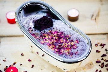 Badewanne gefüllt mit Rosenblättern