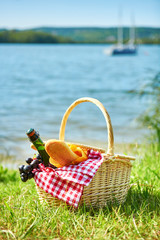 Picnic basket with food near the water