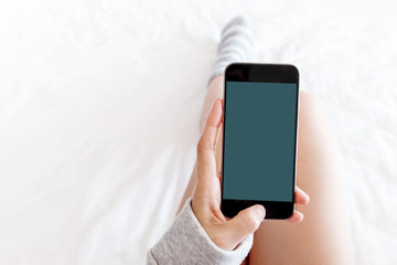 Female using Smart phone on bed, top view