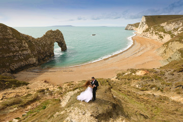 Obraz na płótnie Canvas Groom and bride on the coast