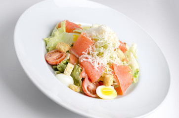 Salad with marinated salmon on a white plate
