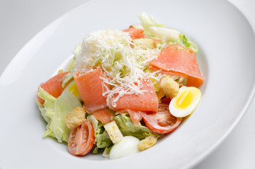 Salad with marinated salmon on a white plate