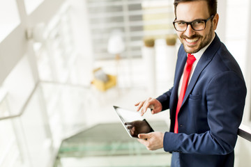 Handsome businessman using tablet in office