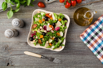Italian salad with fresh vegetables with black olives and Parmesan cheese.