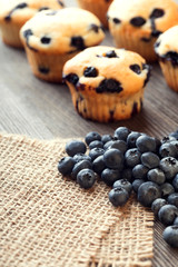 muffin with blueberries on a wooden table. fresh berries and sweet pastries on the board.