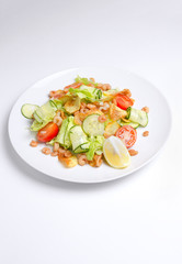 Salad from seafood and vegetables on a white plate