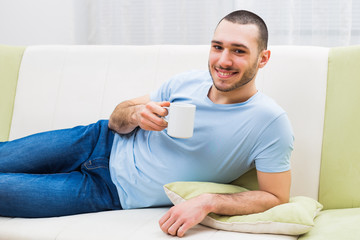 Young man enjoys drinking coffee at home.