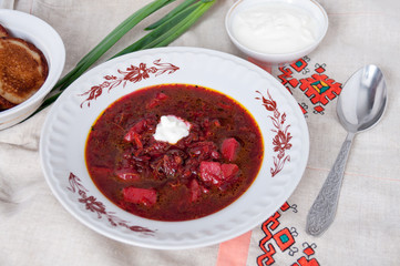 Ukrainian borsch made from beets with sour cream on table